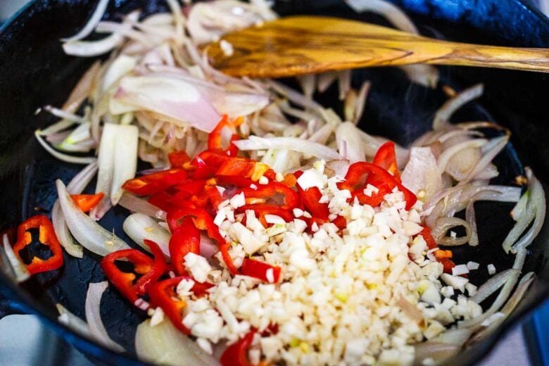 Sautéing shallots, garlic, ginger and peppers for Thai basil chicken.