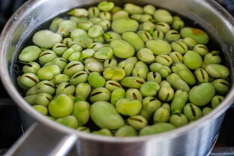 blanching the fava beans in a pot of salted water