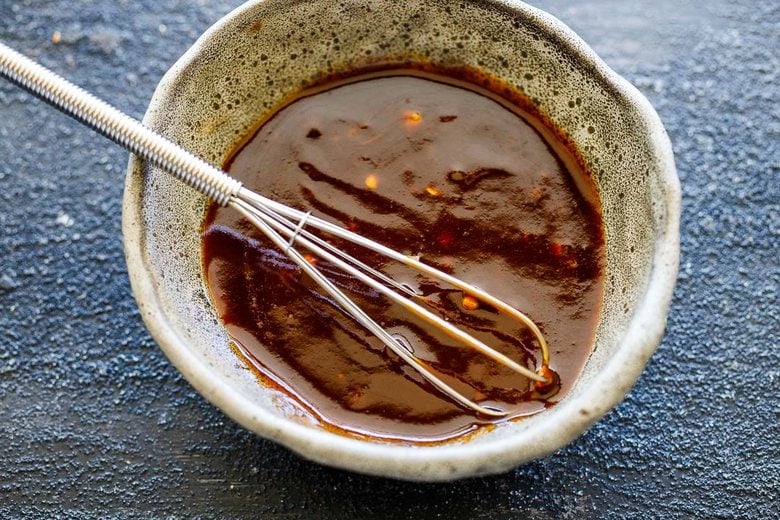mixing bbq sauce and red chili paste in a bowl