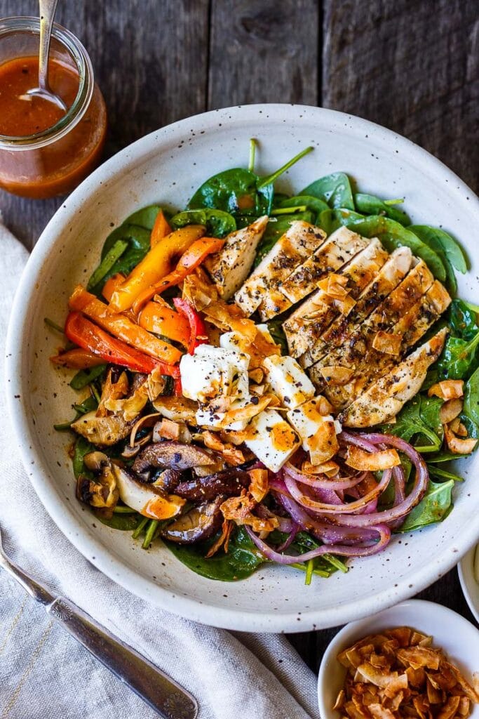 Delicious & hearty Spinach Salad with grilled mushrooms, red onions, sweet peppers, and optional grilled chicken breast, tossed with tangy French Dressing, topped with Coconut Bacon, Feta and hard-boiled eggs. A tasty entree-sized salad, perfect for dinners on the patio!