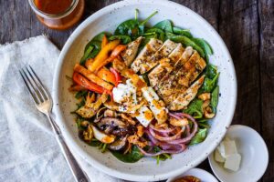 This spinach salad is a twist on the classic with deeply flavored with grilled mushrooms, red onions, sweet peppers and herby grilled chicken.  Topped with our flavorful take on a healthy French style dressing.  A perfect complete dinner for warm days.