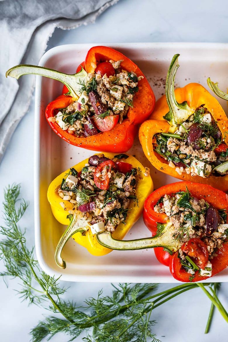 Mediterranean Stuffed Peppers with brown rice, spinach, feta, tomatoes, herbs, and your choice of protein. Easy, healthy, and flavorful.