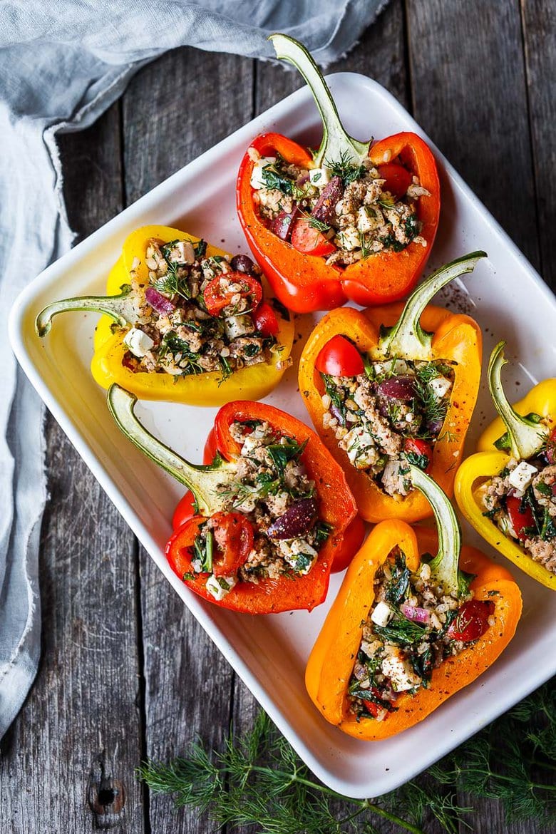 Mediterranean Stuffed Peppers with brown rice, spinach, feta, tomatoes, herbs, and your choice of protein. Easy, healthy, and flavorful.