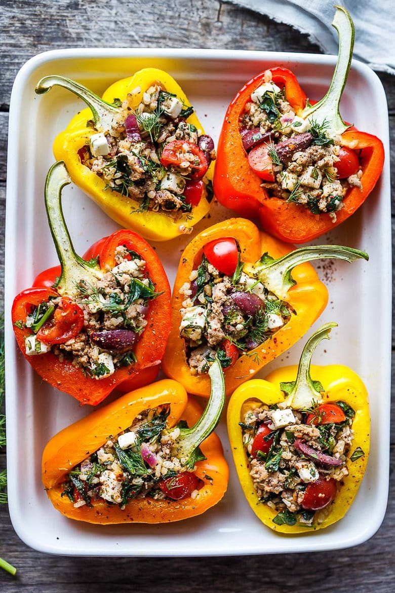 Mediterranean Stuffed Peppers with brown rice, spinach, feta, tomatoes, herbs, and your choice of protein. Easy, healthy, and flavorful.