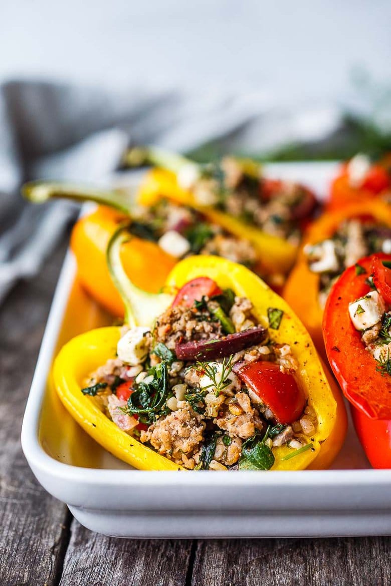 Mediterranean Stuffed Peppers with brown rice, spinach, feta, tomatoes, herbs, and your choice of protein. Easy, healthy, and flavorful.