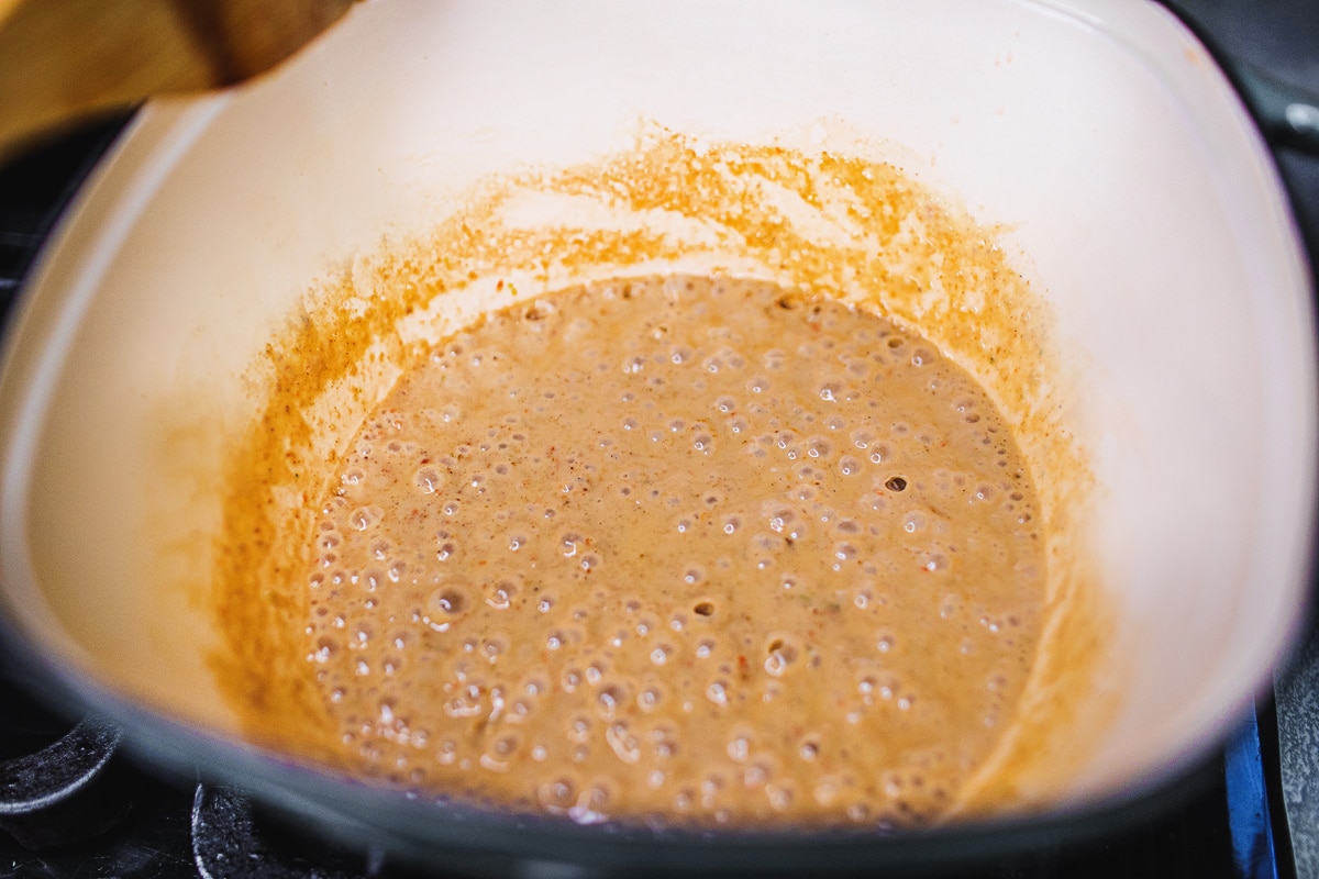 coconut milk and red curry paste simmering