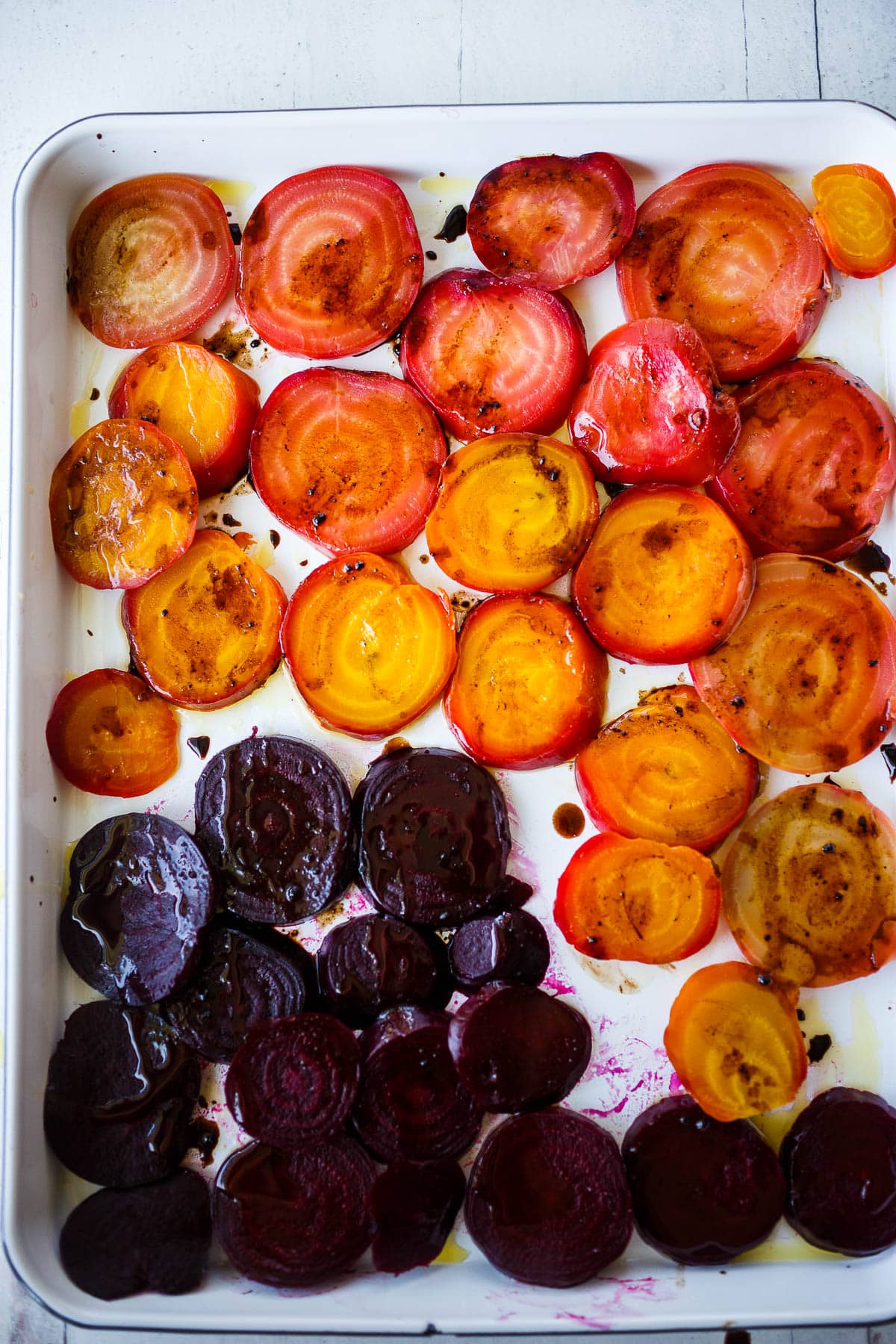 sliced beets on a tray with oil and balsamic