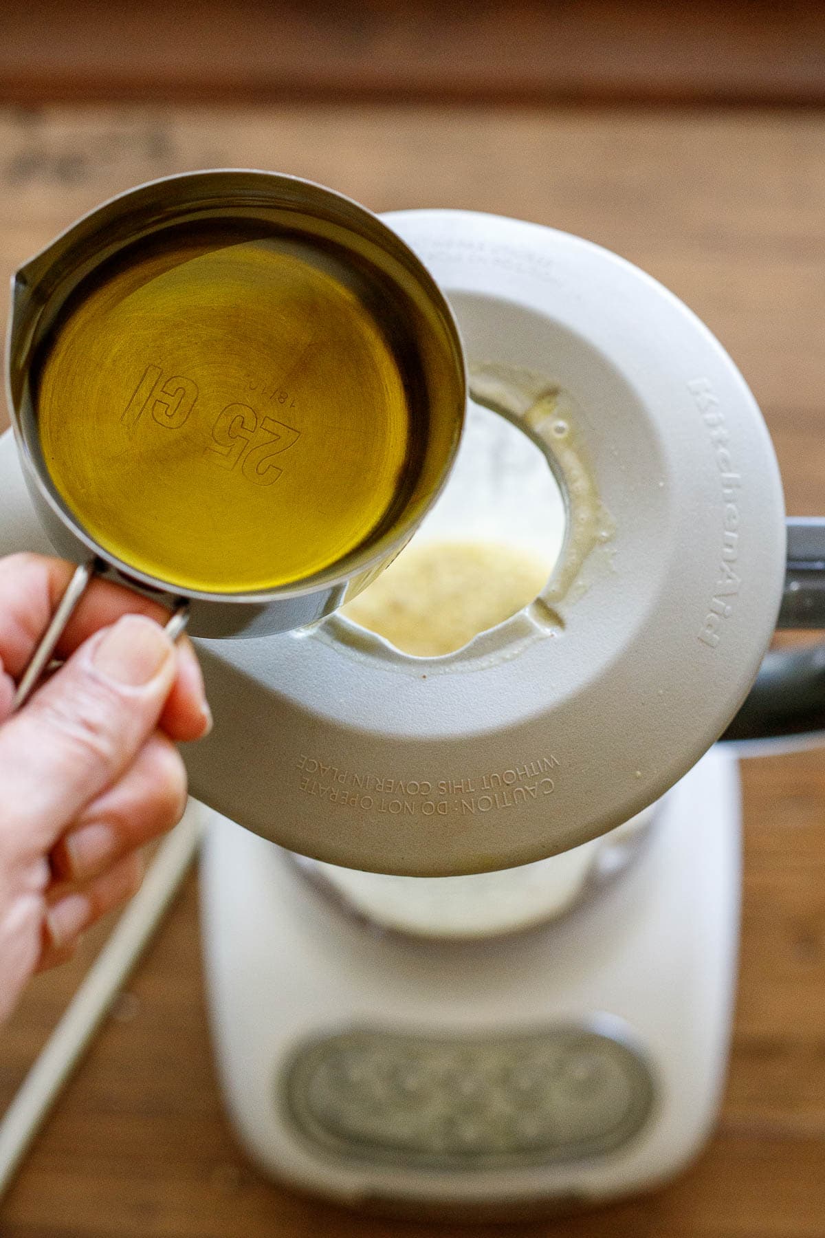 adding olive oil to the blender