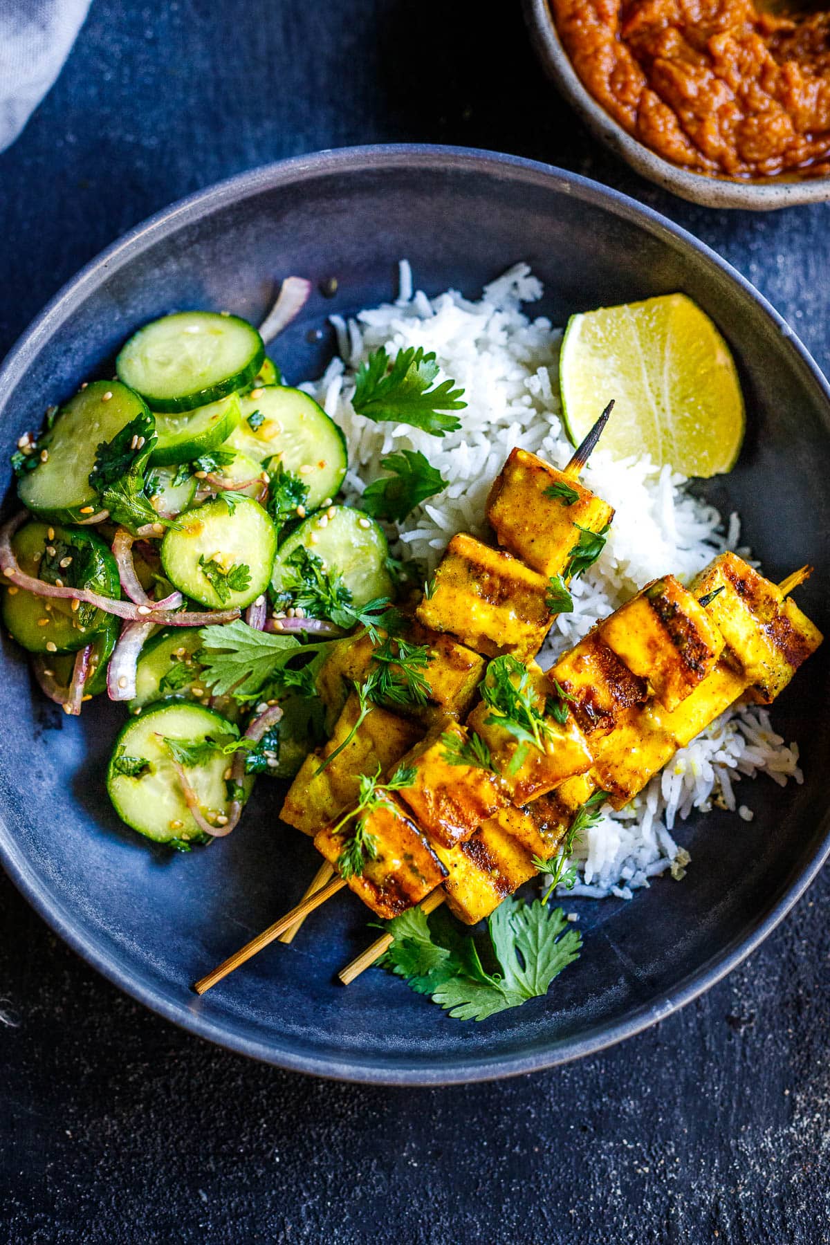 Tofu Satay with Peanut dipping suace and cucumber salad served over coconut rice.