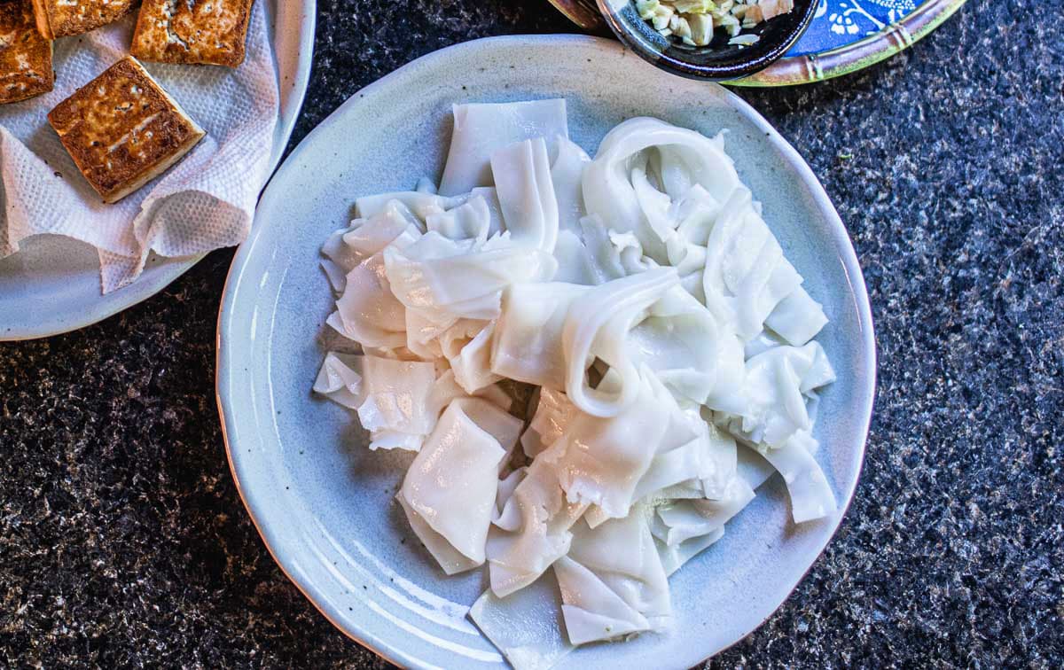 wide rice noodles on a plate on the counter