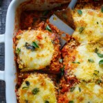 3 large eggplants, cut into -1/3 inch thick rounds 2 eggs, beaten 1/4 cup water ½ teaspoon salt ½ teaspoon pepper 2 cups panko breadcrumbs ( panko is lighter than traditional breadcrumbs)  1 ½ cups parmesan cheese (divided)  1 teaspoon dried oregano 2 tablespoons fresh thyme 3/4 teaspoon salt  3/4 teaspoon pepper Spray olive oil 28 ounces Marinara Sauce 12 ounces fresh mozzarella balls, thinly sliced ( or use grated) Garnish:  fresh basil, chili flakes