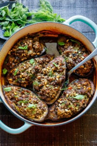 This Stuffed Eggplant recipe is so cozy and warming! Succulent eggplant is filled with basmati rice, your choice of ground meat (or lentils), herbs, and Lebanese spices and baked until meltingly tender, in a fragrant tomato broth. Vegan-adaptable.