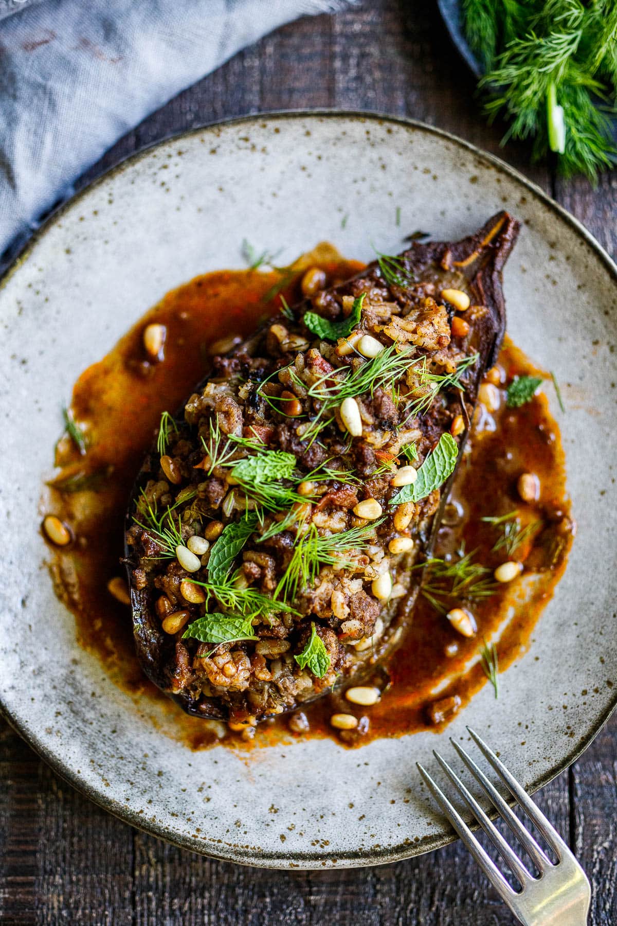 Succulent Stuffed Eggplant infused with Lebanese spices, baked in the oven until meltingly tender. Filled with basmati rice, your choice of ground meat (or lentils) herbs, and pine nuts in a fragrant tomato broth. Vegan-adaptable.