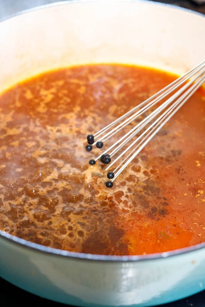 Whisking broth in the pan.