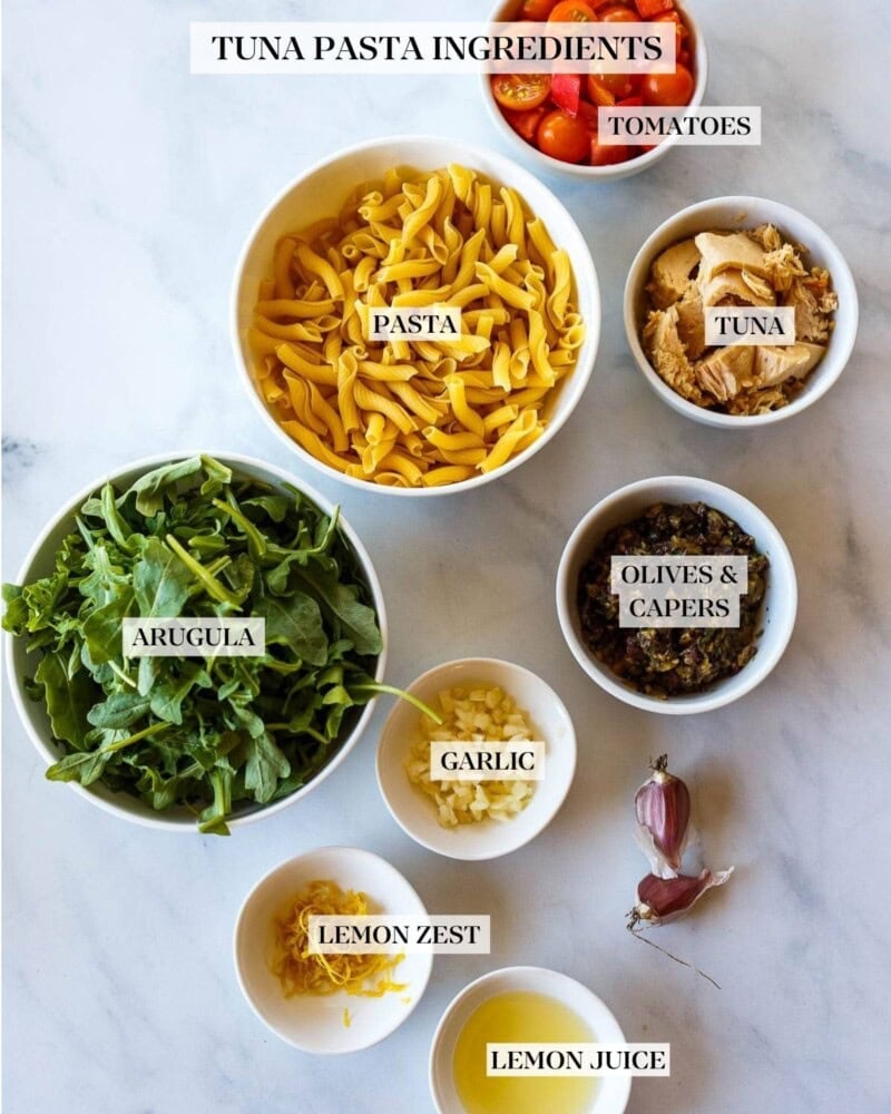Tuna pasta ingredients - pasta, olives, capers, tuan, arugula, tomatoes, lemon zest and garlic. 