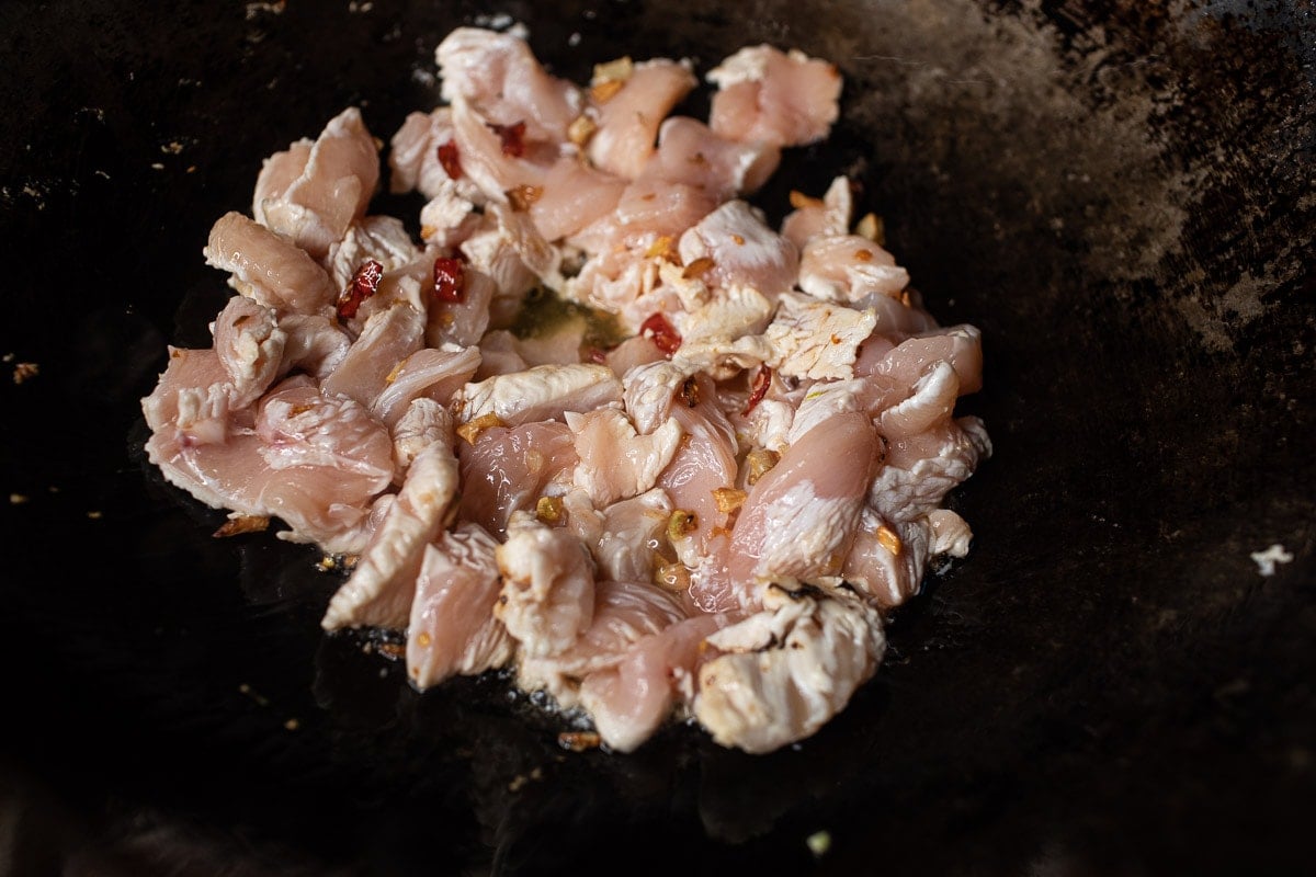 friend chicken and chilis in a wok