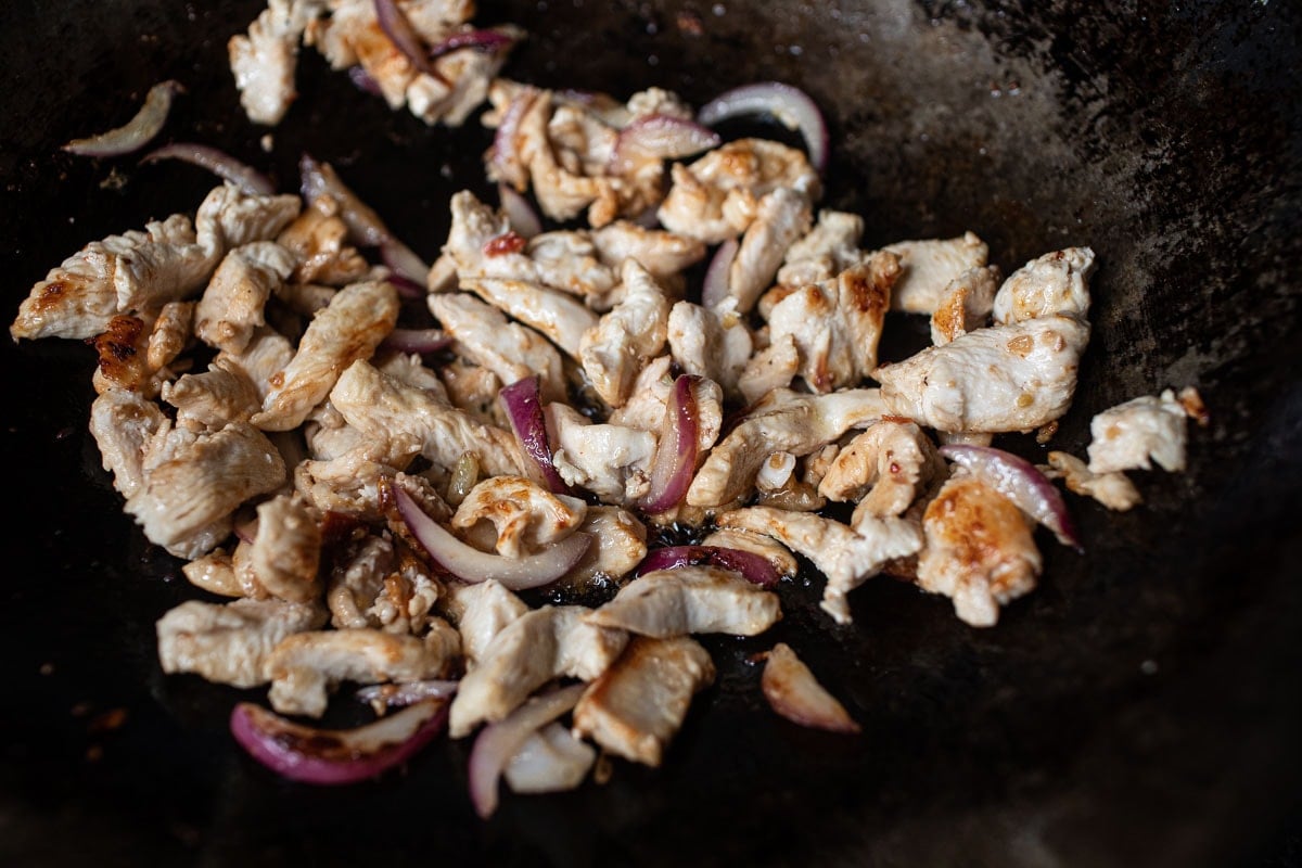 chicken and shallot fried in a wok