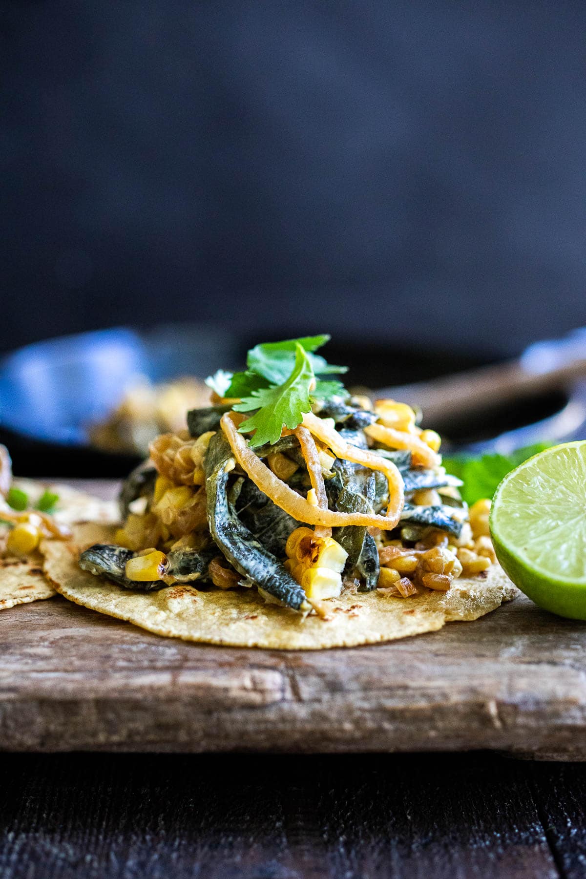 Rajas Tacos are made with strips of poblano peppers, onions and corn, with a hint of Mexican Crema served with cilantro and lime. Vegan-adaptable