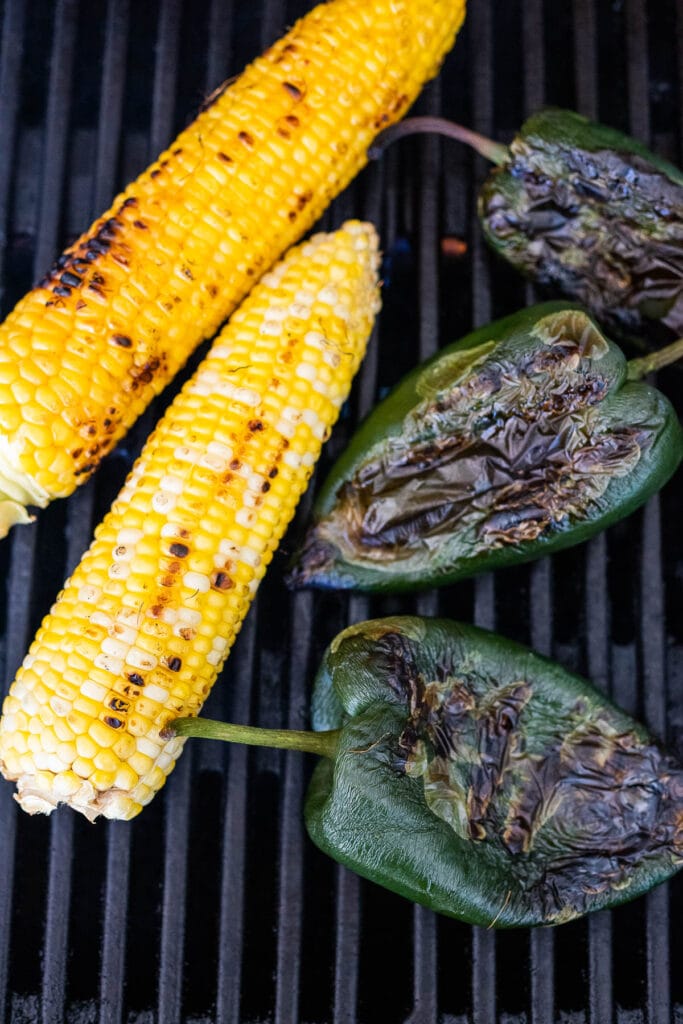 corn and poblano peppers on the grill charring.
