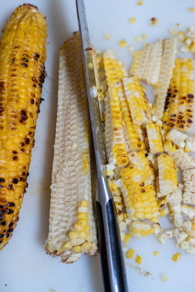cutting the charred corn kernals off the cob.