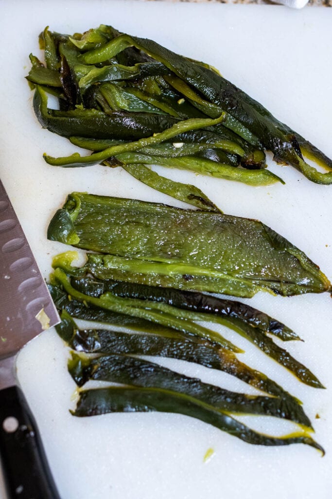 slicing the poblano peppers into strips for rajas.