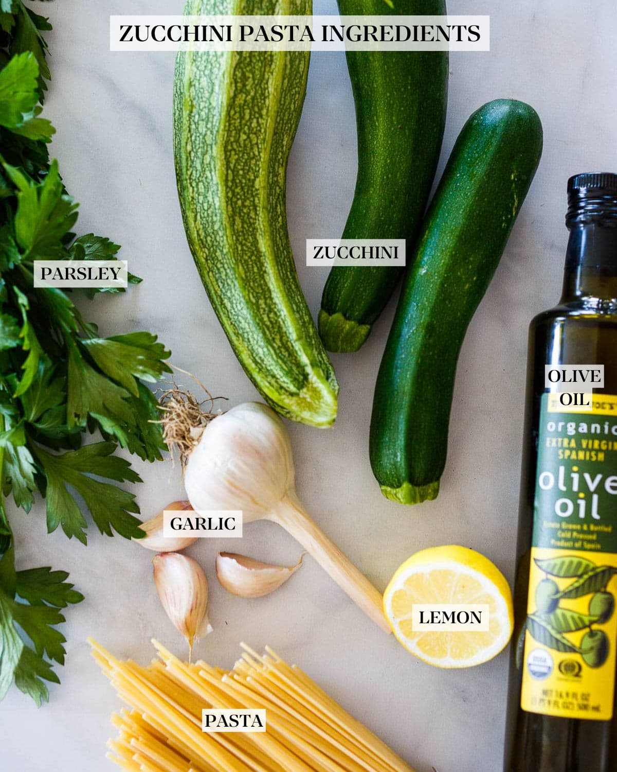 Zucchini and pasta layed out with ingredients for zucchini pasta sauce.