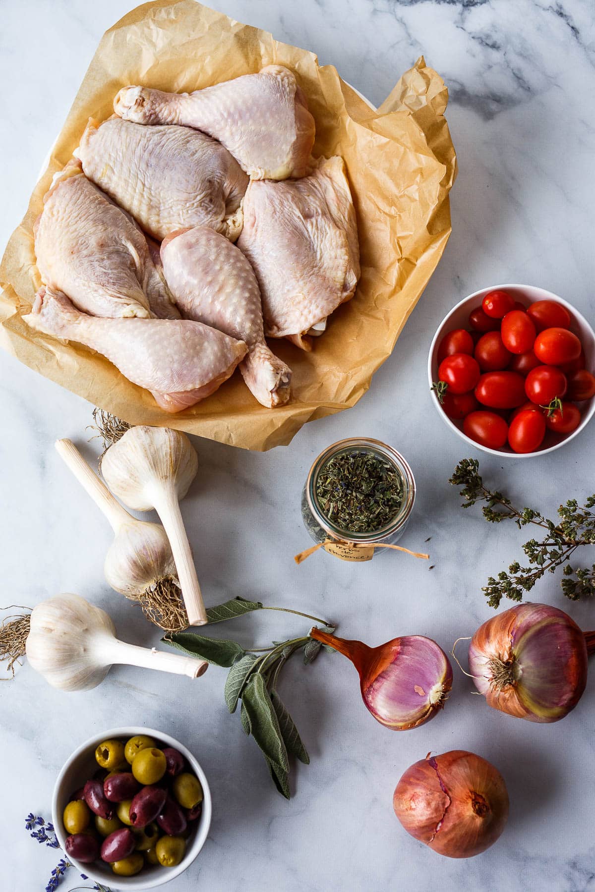 Ingredients for Chicken Provençal-Chicken thighs and legs with herbs de Provence, tomatoes, shallots, garlic, olives.
