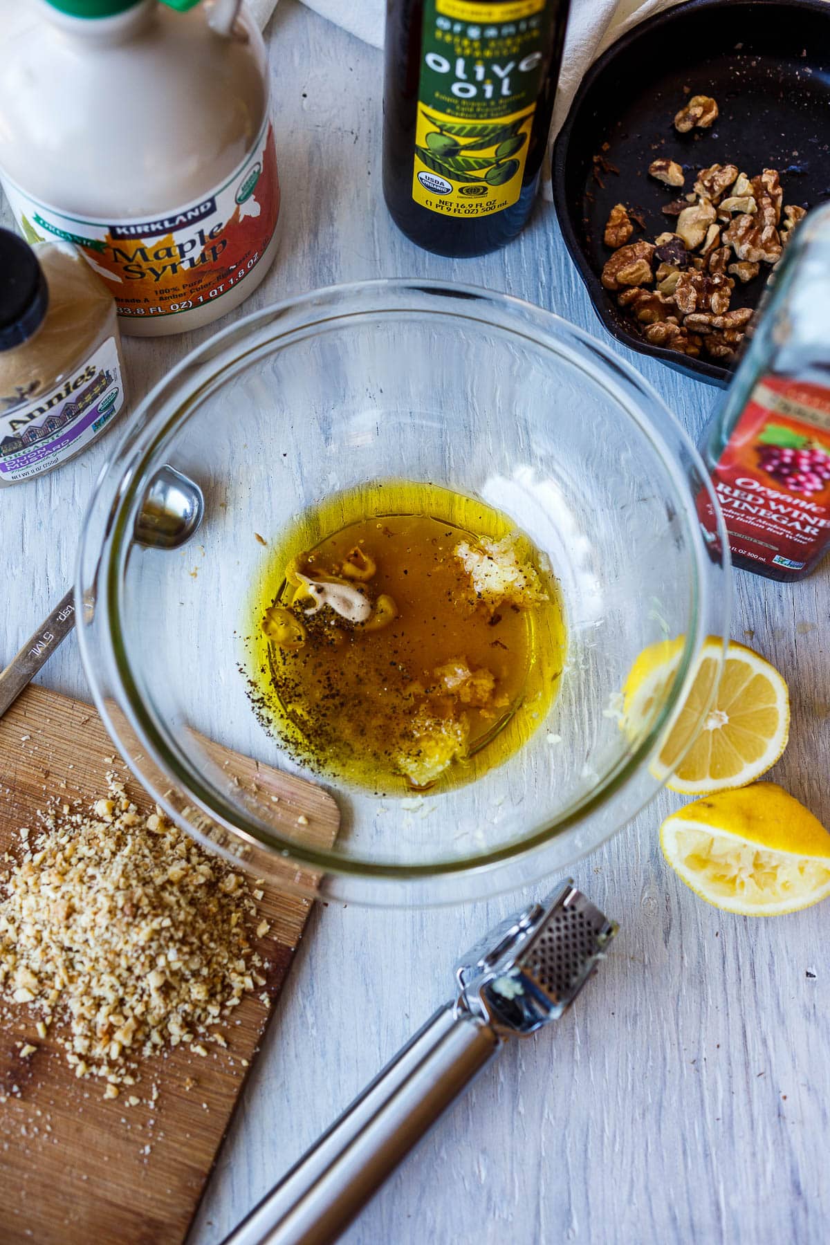Whisking all ingredients together in a glass bowl for the toasted walnut vinaigrette.