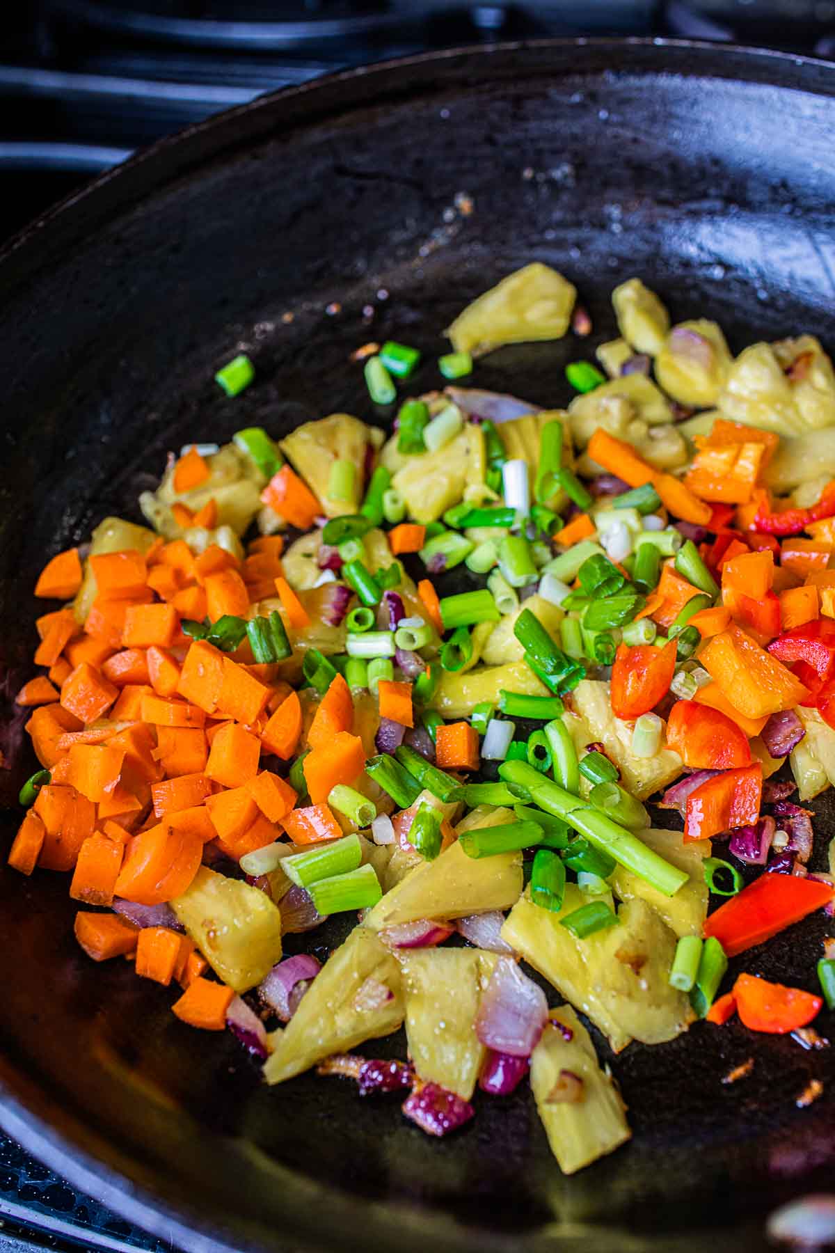 sautéed vegetables and pineapple in a pan