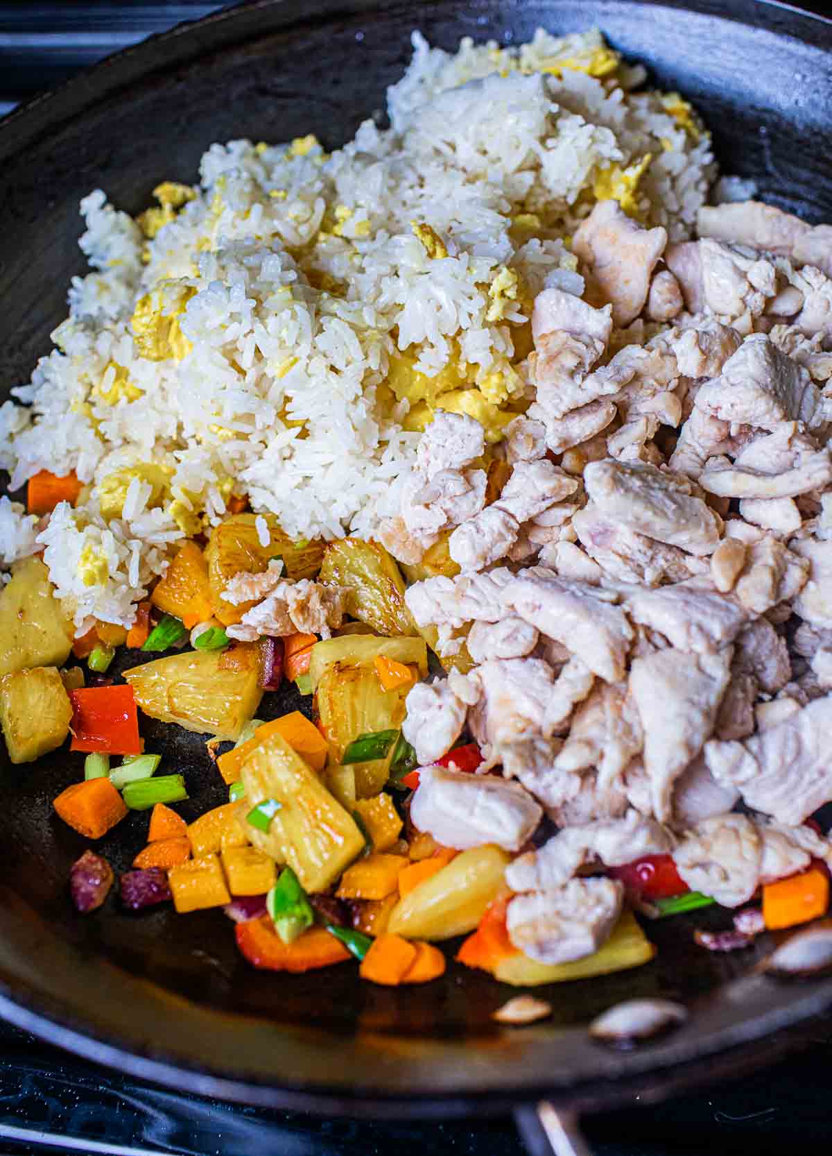 fried rice with eggs, chicken and pineapple in a wok