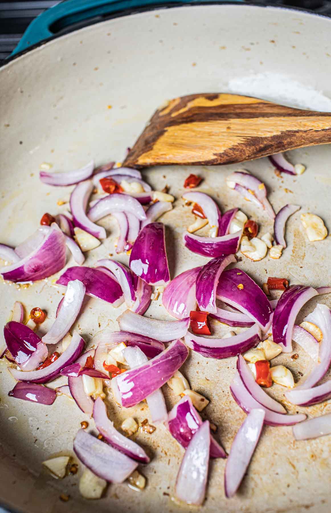 purple onion, garlic and chilis in a stir frying pan