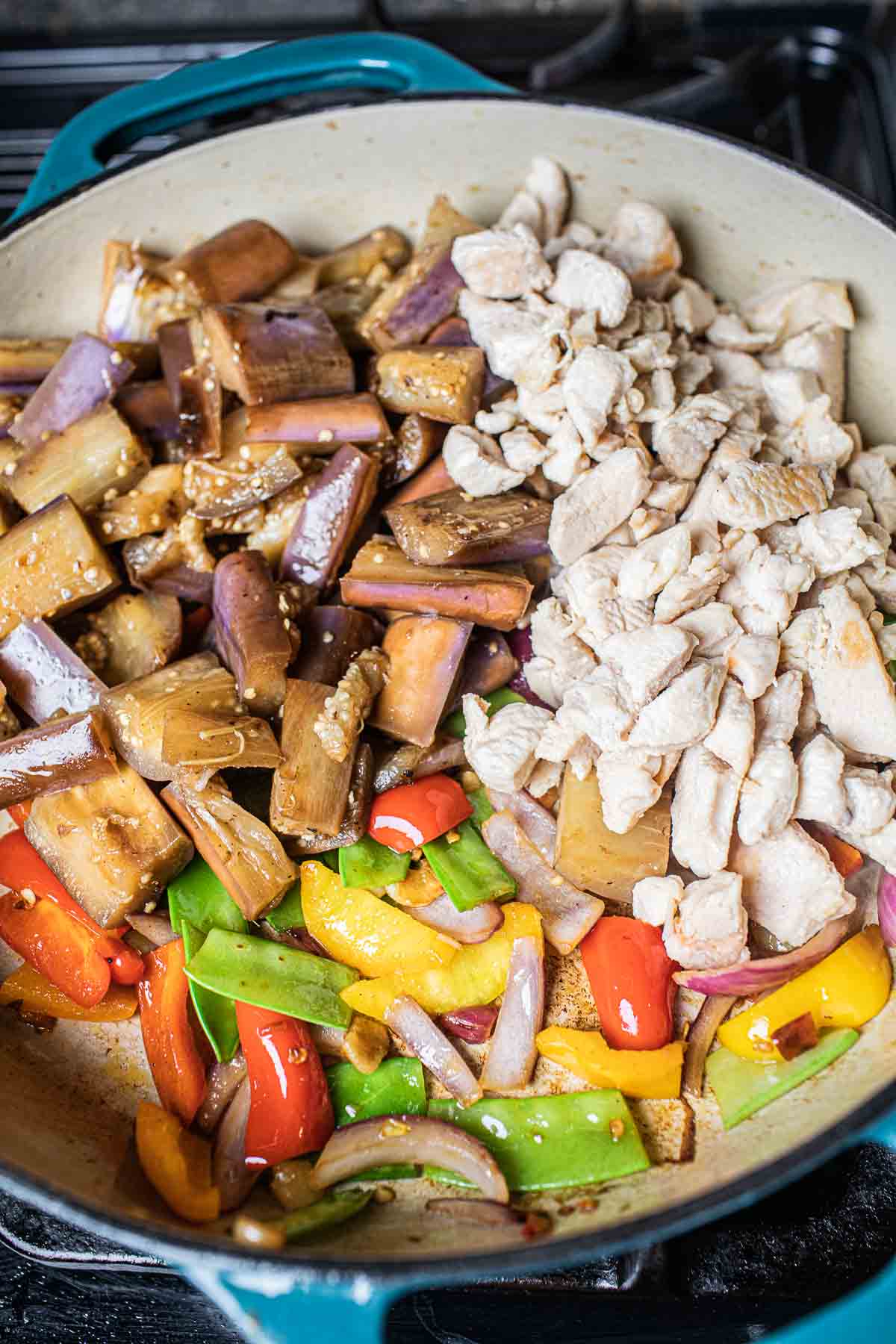 Chicken, eggplant, vegetables in a stir frying pan