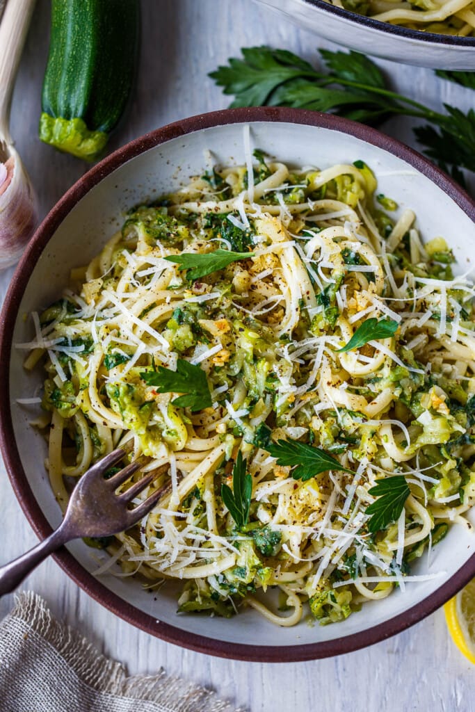 Here's a quick and simple recipe for Easy Zucchini Pasta. Grated zucchini melts into a flavorful succulent sauce, perfect for cradling linguini or your favorite pasta! Enhanced with lemon, black pepper and garlic you'll have dinner on the table in 30 minutes! Vegan and gluten-free adaptable.