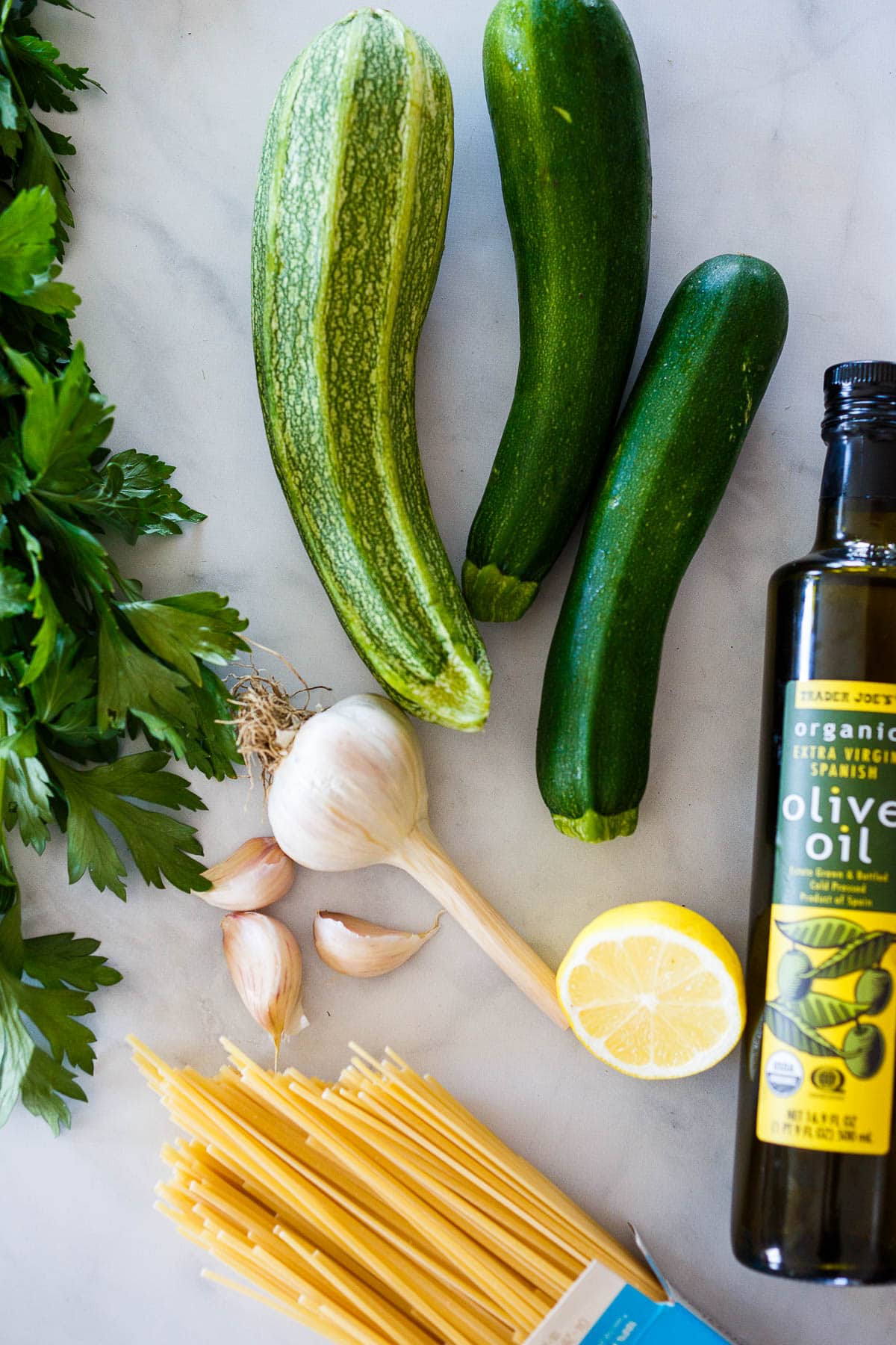 Zucchini and pasta layed out with ingredients for zucchini pasta sauce.