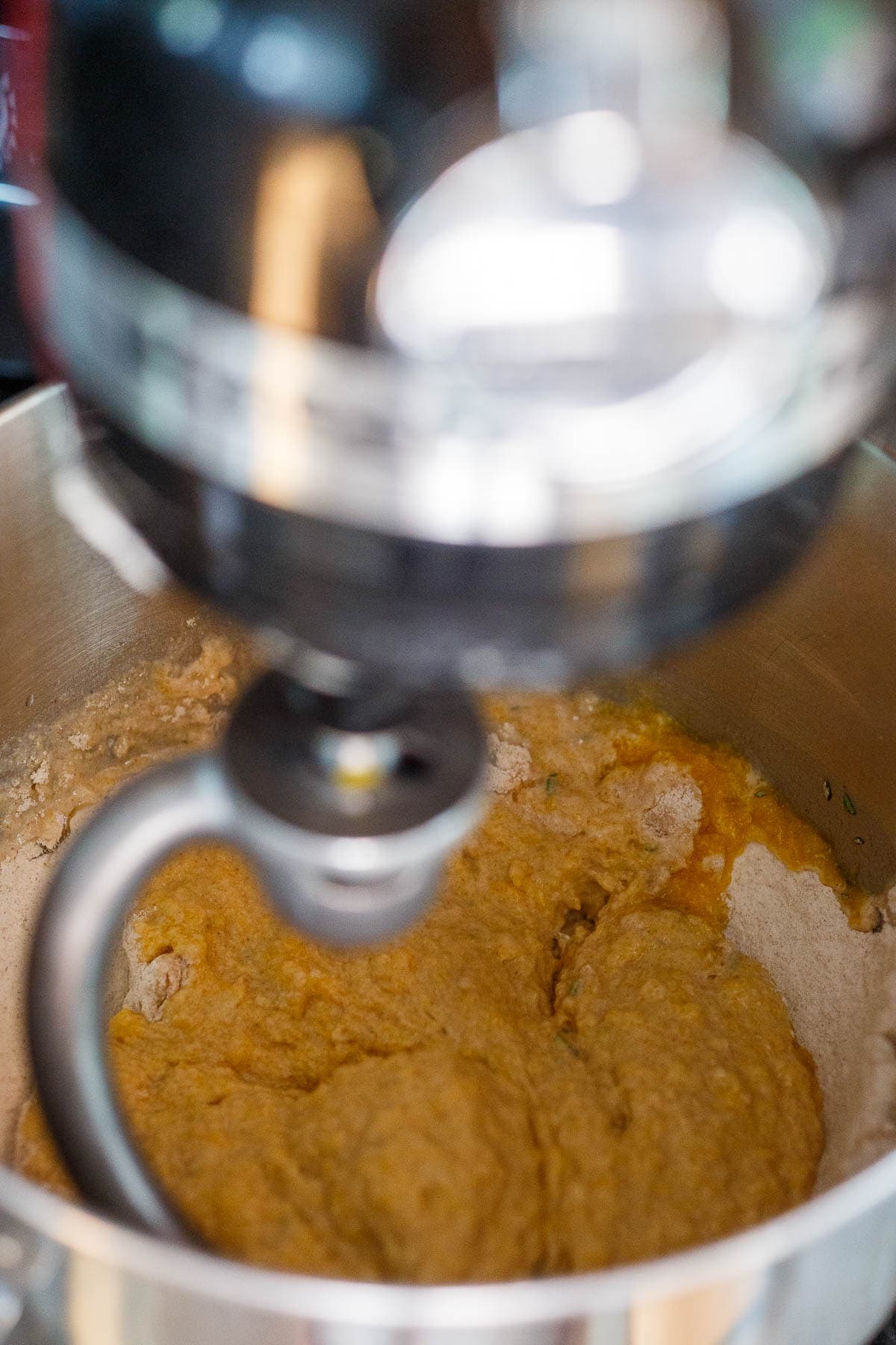 Mixing dinner rolls together in a standup mixer.