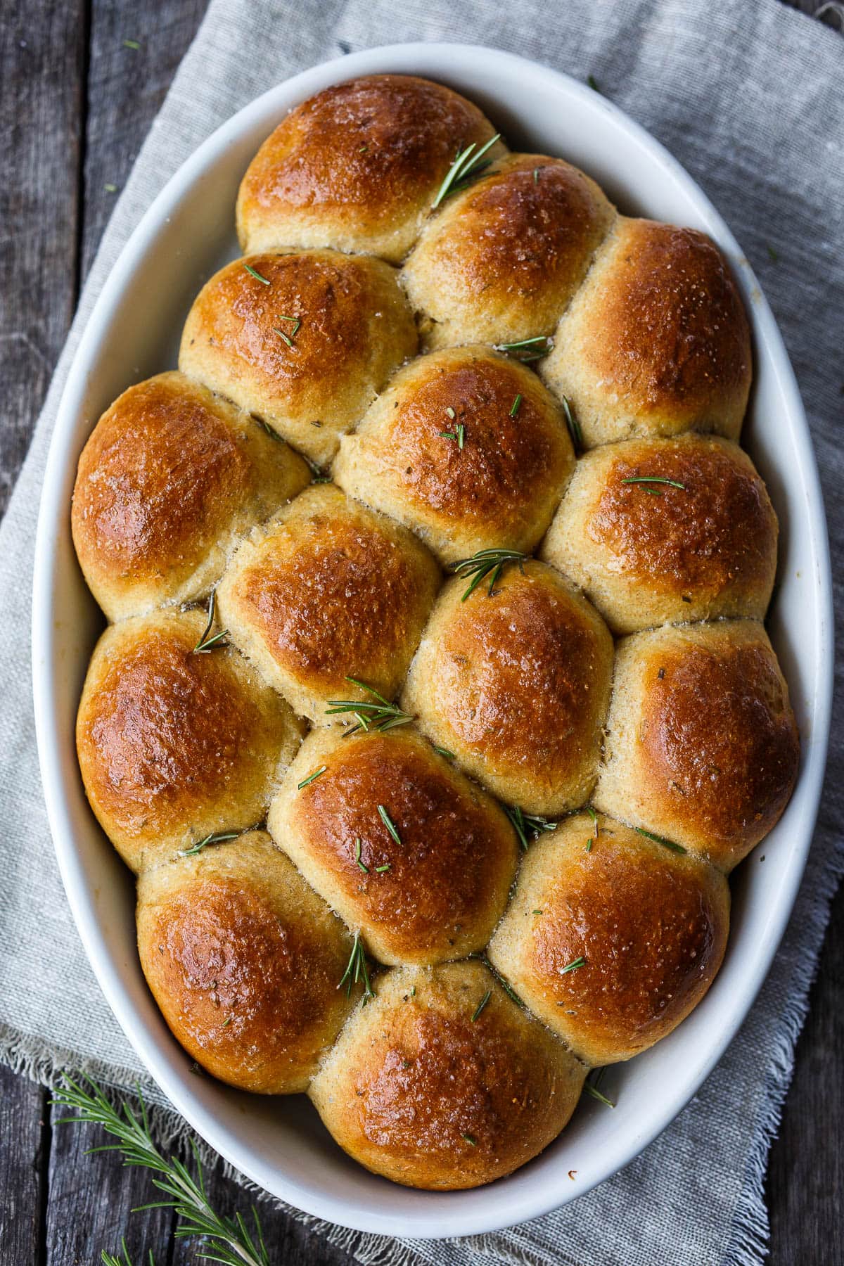 Golden and tender these whole wheat, pull-apart, Butternut Squash Dinner Rolls are flecked with rosemary and completely irresistible.  Roasted squash cooked into the roll ensures that they are soft and full of flavor with just a hint of sweetness.  