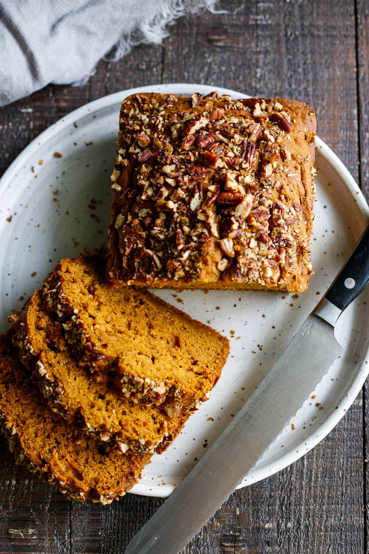 A delicious recipe for Pumpkin Bread with double the spices. This version is maple sweetened, with a crunchy nut topping, optional chocolate chips, and a moist tender crumb. Vegan-adaptable. 