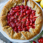 This Strawberry Galette is bright, cheery and full of springtime flavor. Lemon and rosemary perfectly compliment the sweet berries. A rustic flaky rye pastry crust encloses the succulent filling.