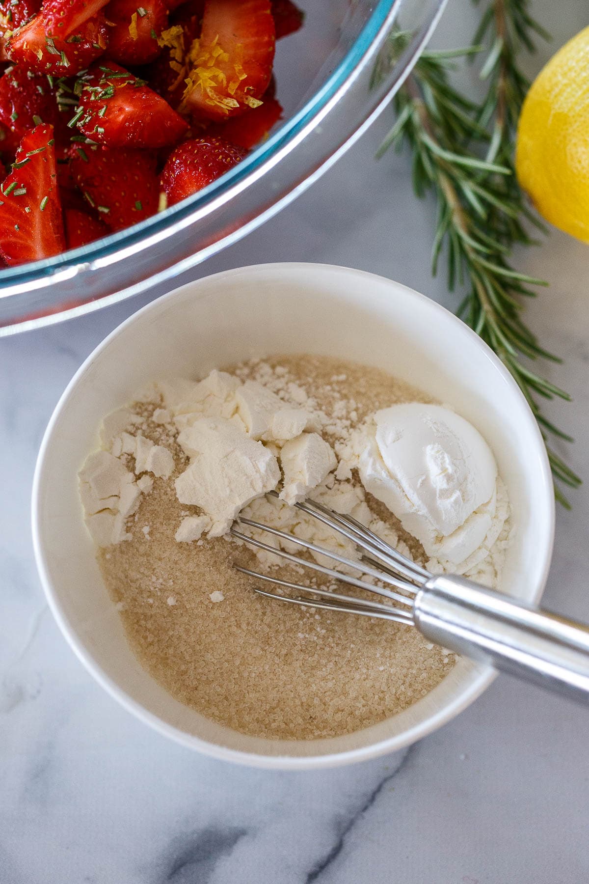 Sugar and cornstarch in a bowl with a whisk.