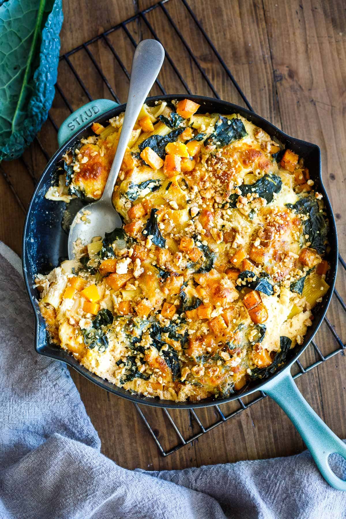 cast iron skillet with baked rigatoni with butternut squash and kale. 