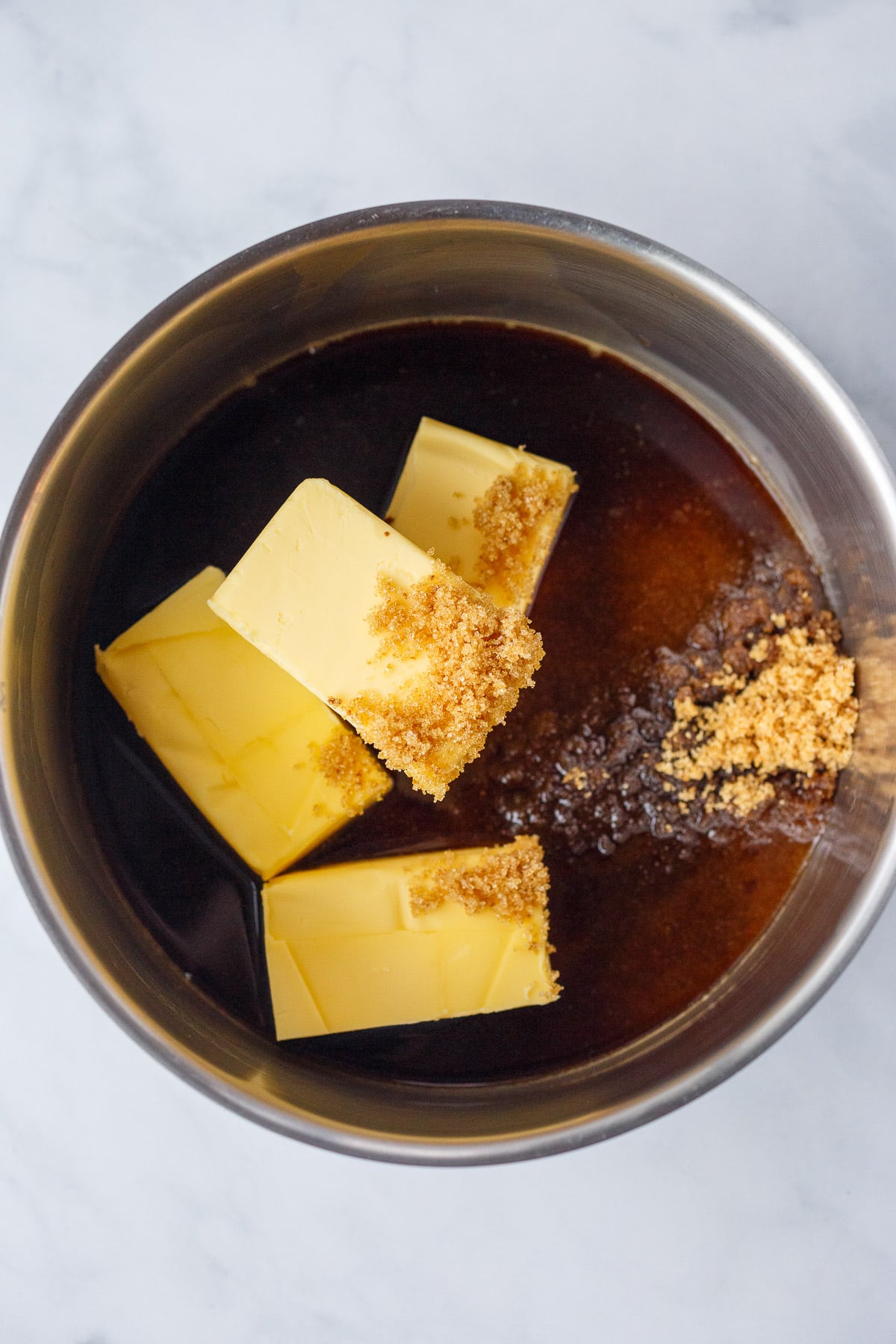 A sauce pan with butter, coffee, and brown sugar. 