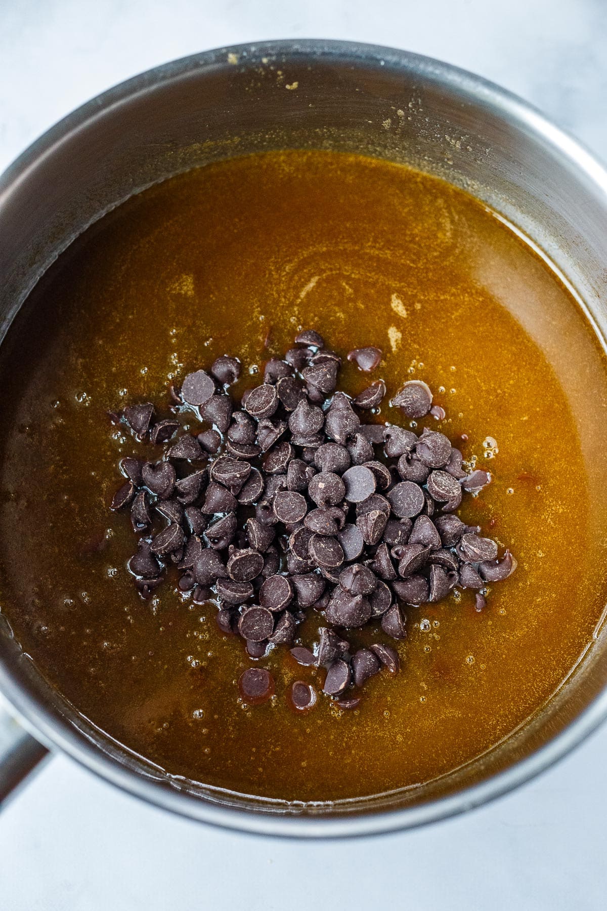 Butter, coffee, and brown sugar melted together in a sauce pan with chocolate chips.
