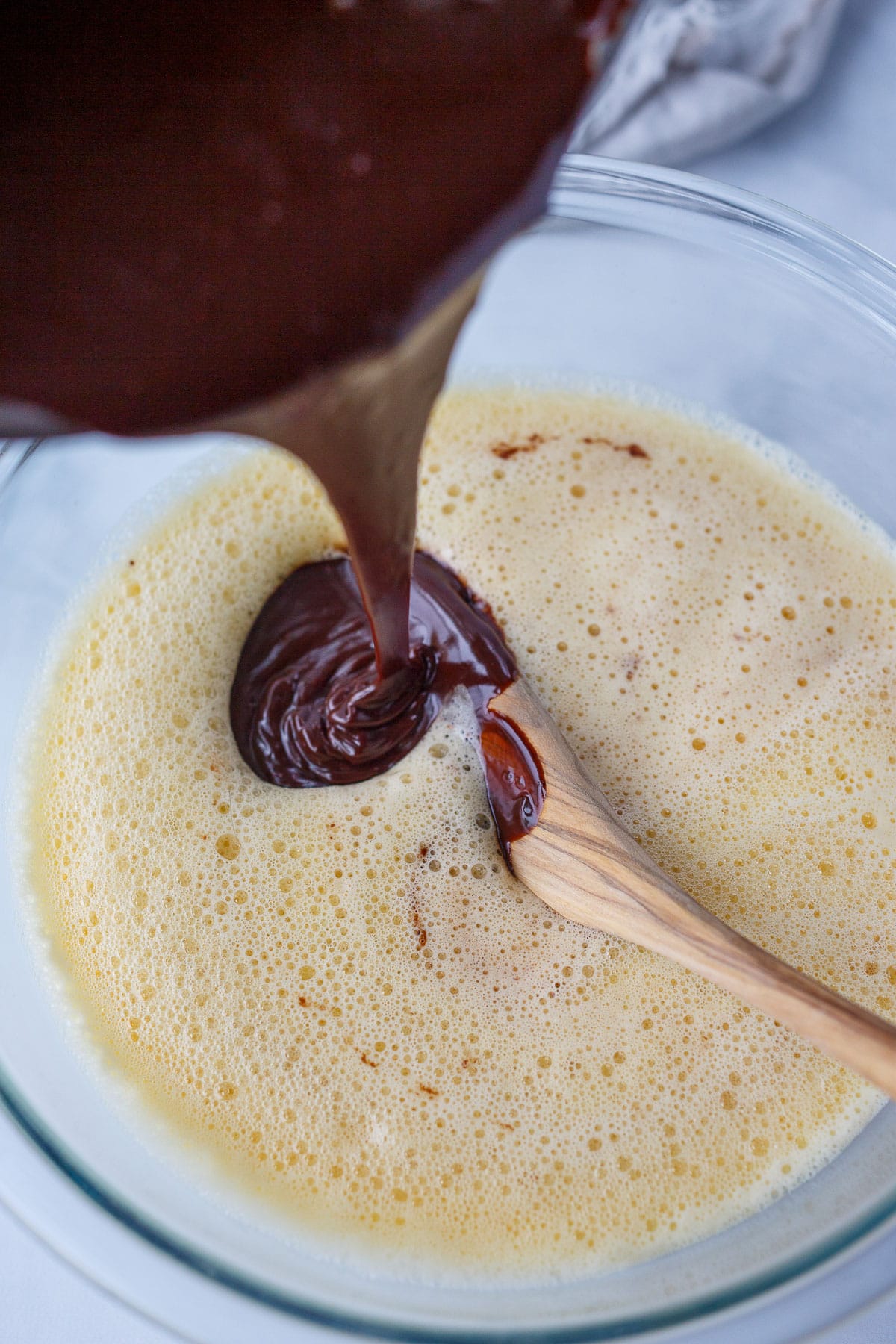 Pouring chocolate into the frothy eggs.