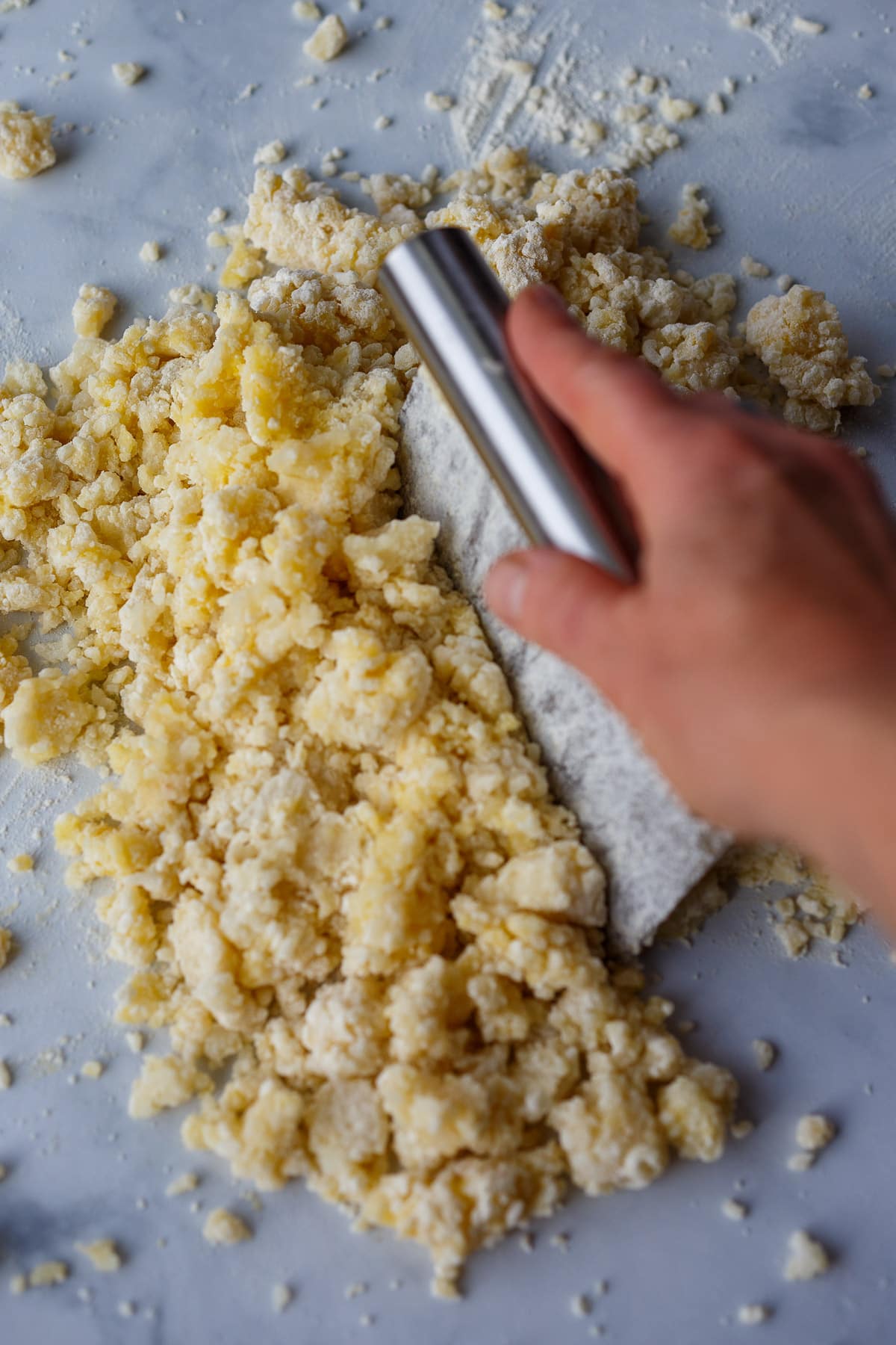 Bringing dough together with a bench scraper.