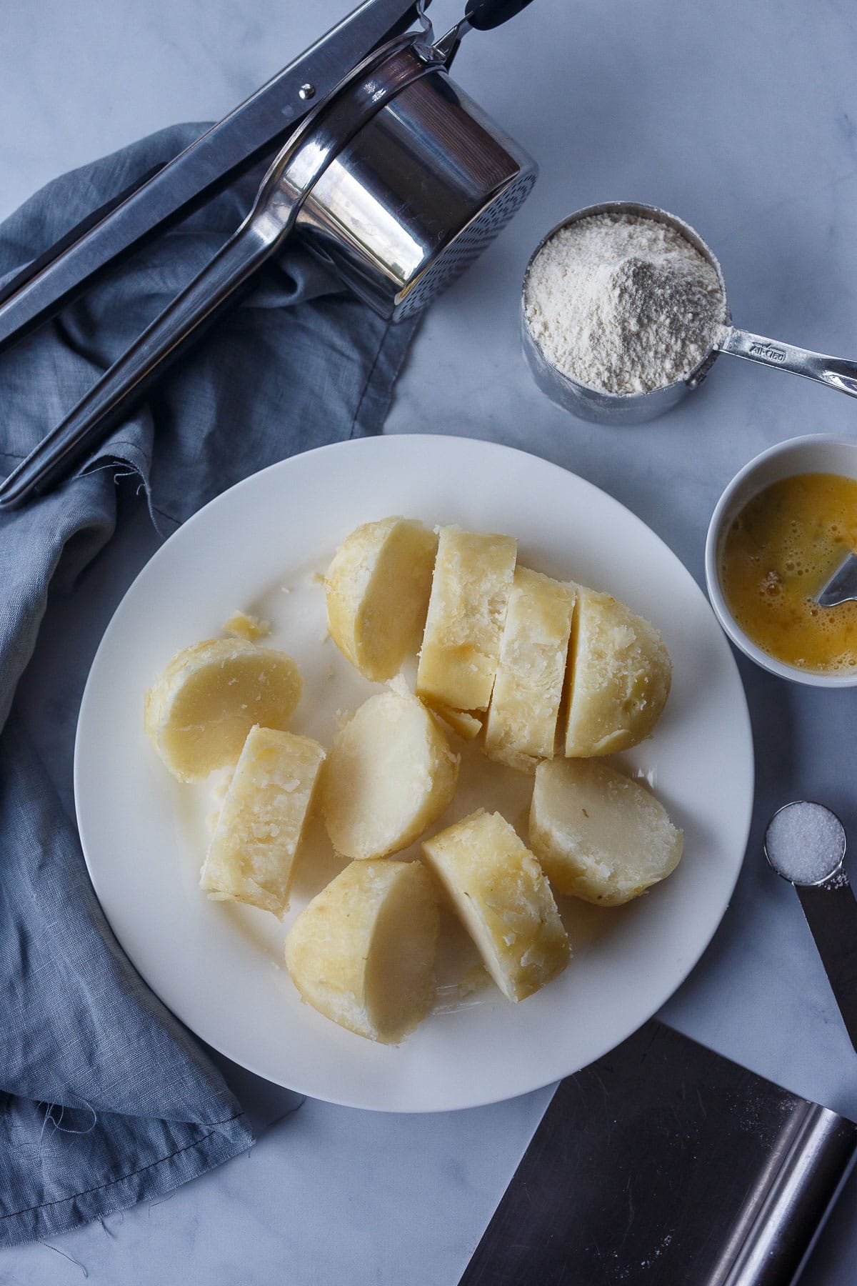 Potato ricer, flour, beaten eggs, salt, potato chunks.