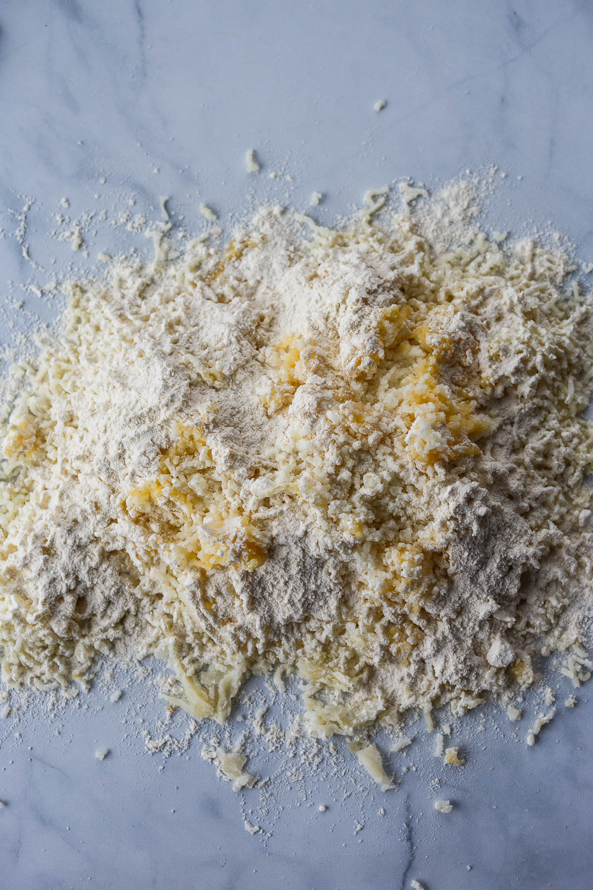Riced potatoes mixing with egg and flour.