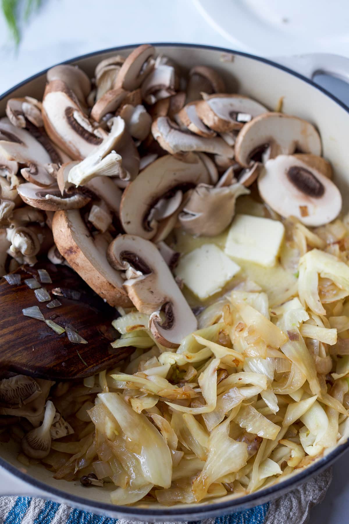 Adding mushrooms to the fennel and shallots.