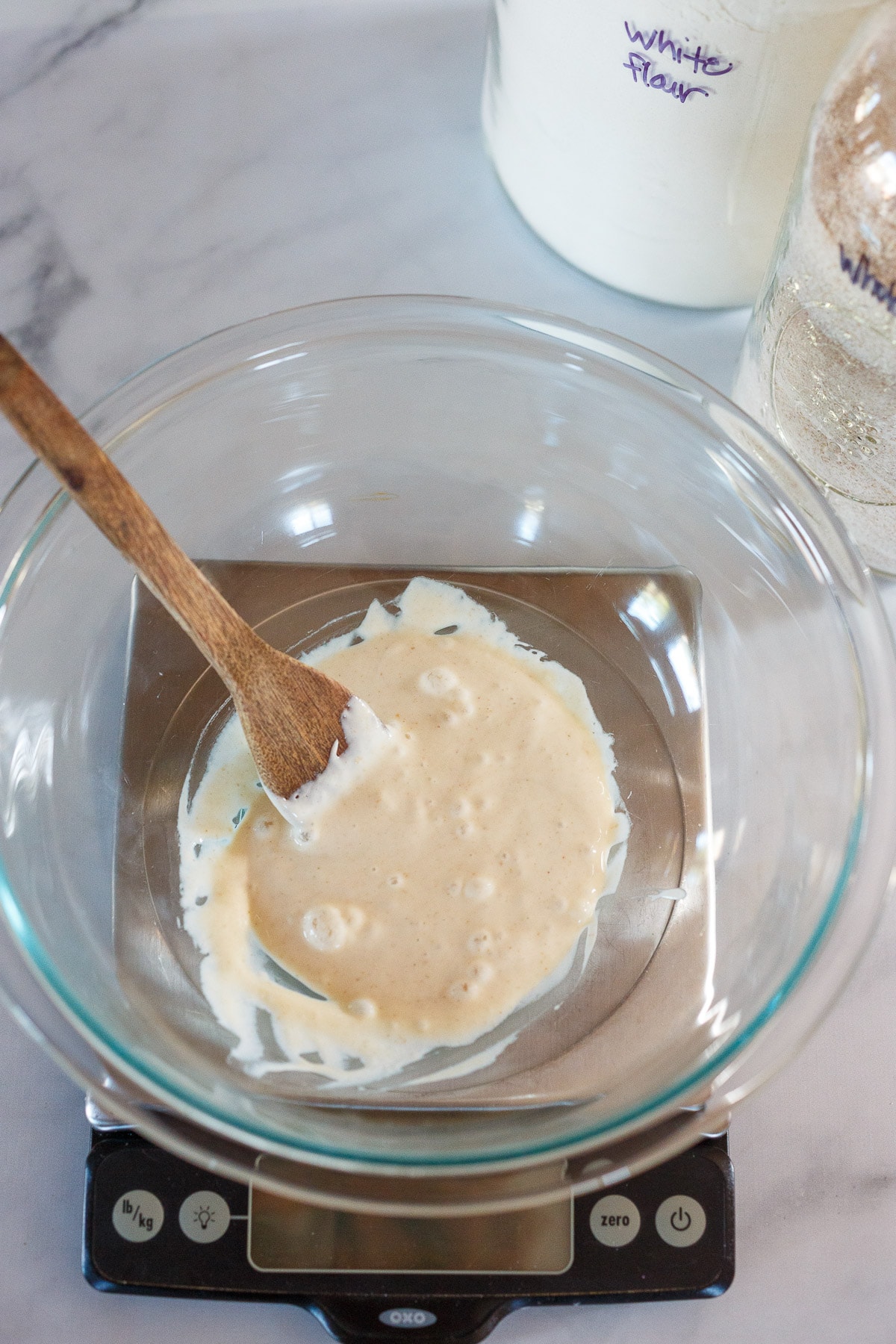 Mixing the starter in a glass bowl on a scale.