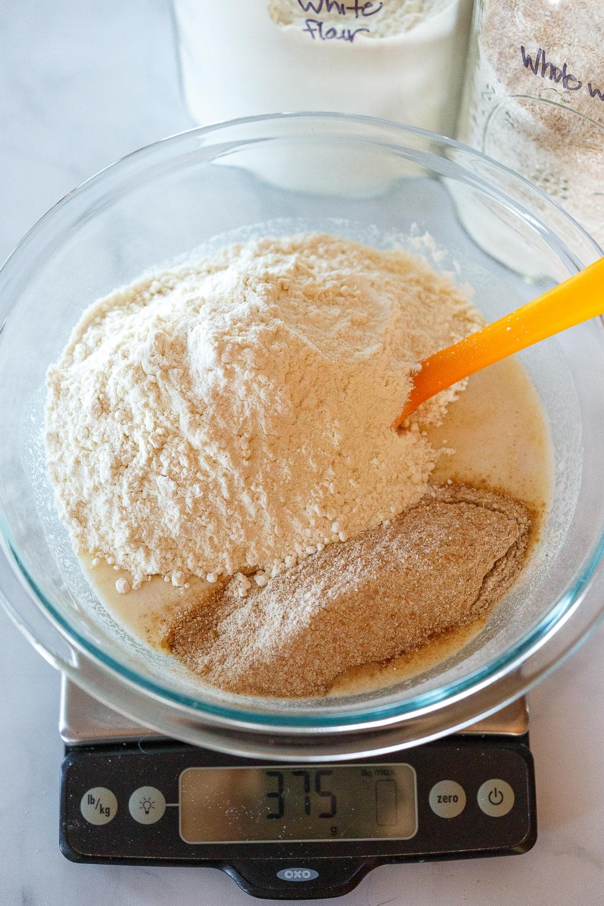 Weighing the flour in the mixing bowl with starter.