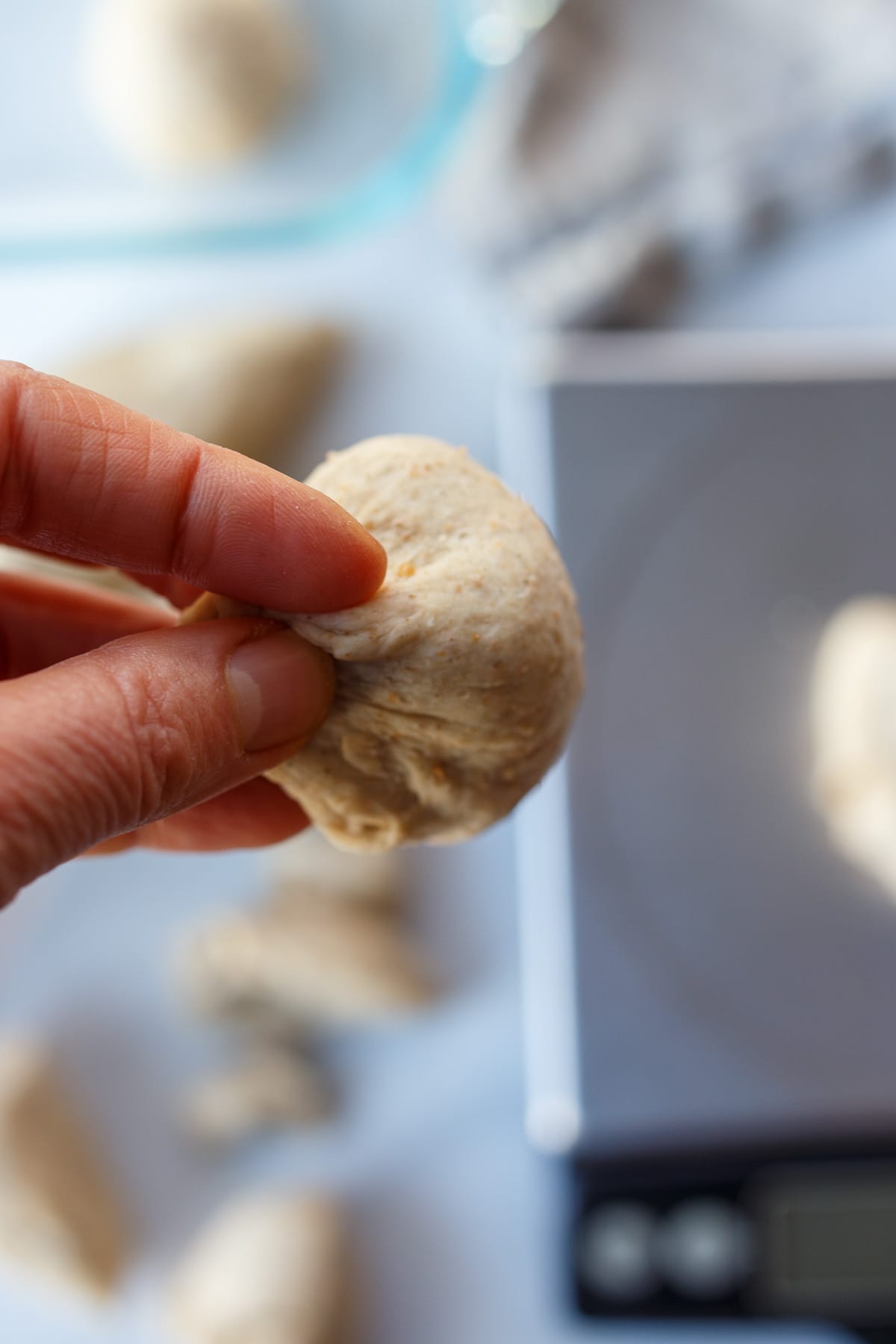 Pinching dough at the bottom to form the roll.